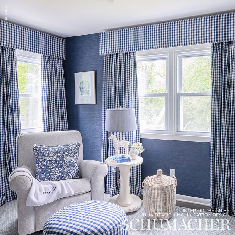 Blue-and-white gingham living room with a light gray armchair, white round side table, floral pillow, and a woven basket.