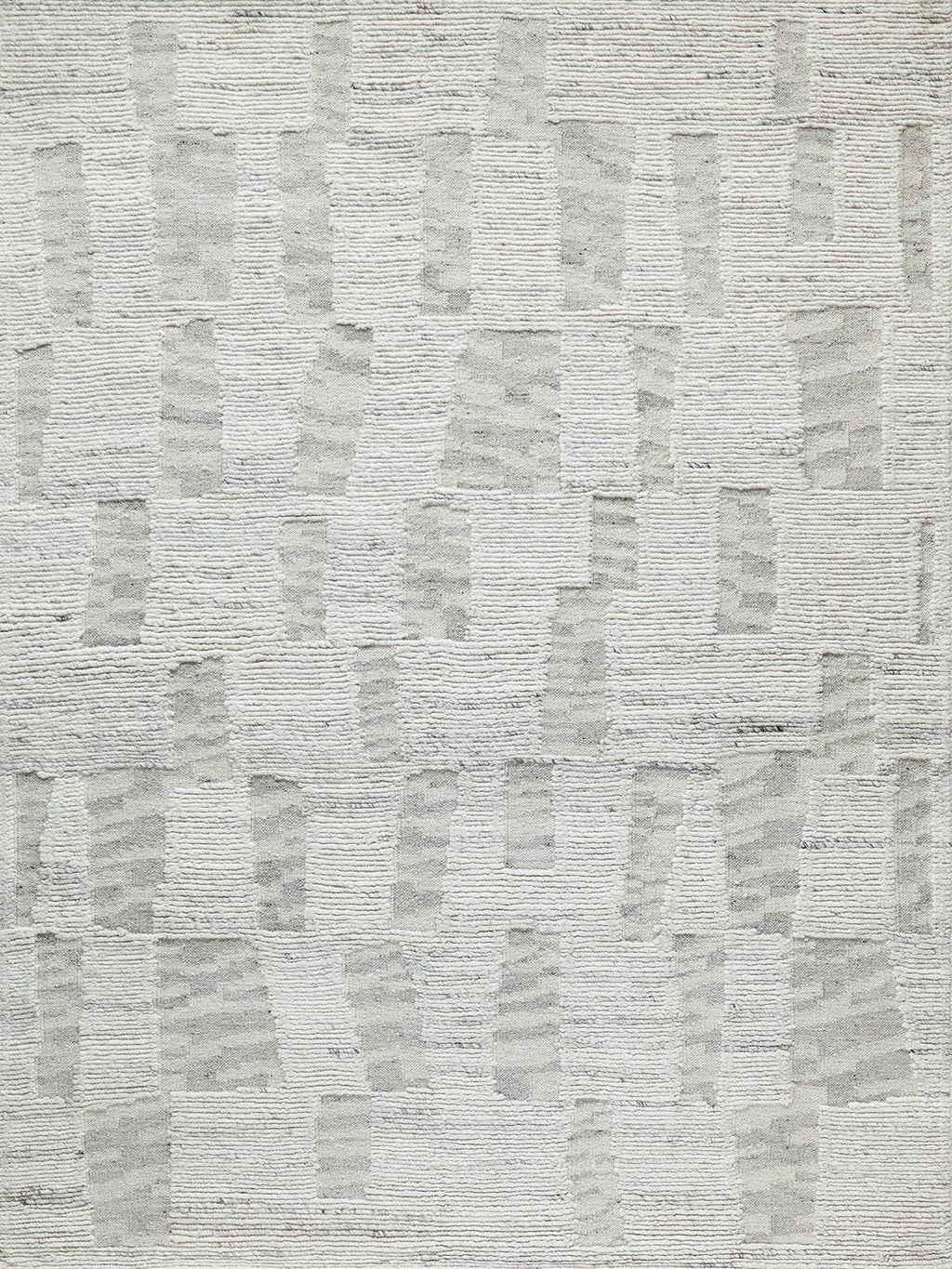 Textured area rug in soft gray hues, featuring an abstract pattern with varied rectangular shapes, perfect for modern decor.