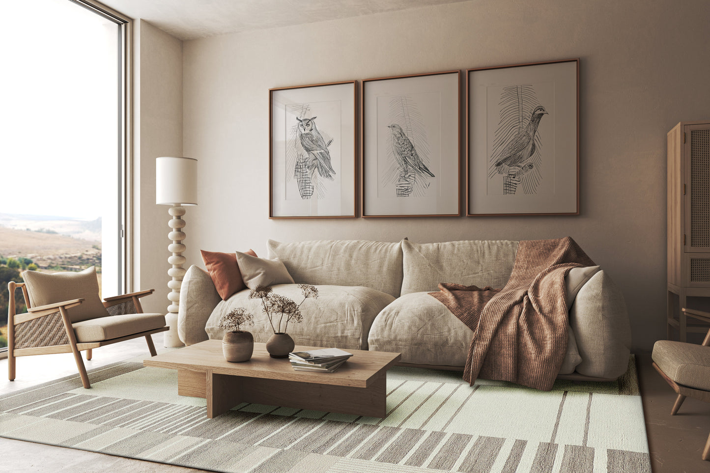 Bright modern living room with beige sofa, brown throw, wooden coffee table, striped rug, three bird prints, window view.