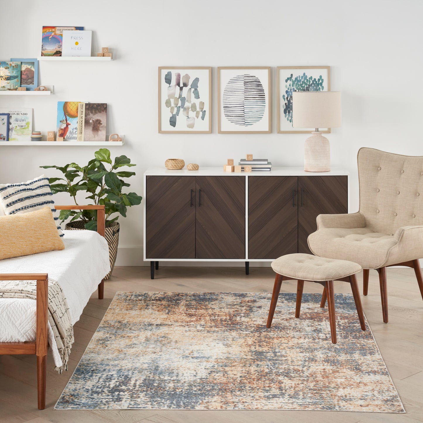 Cozy modern bedroom with dark wood sideboard, beige tufted armchair & matching ottoman, patterned area rug, plant & framed wall art.