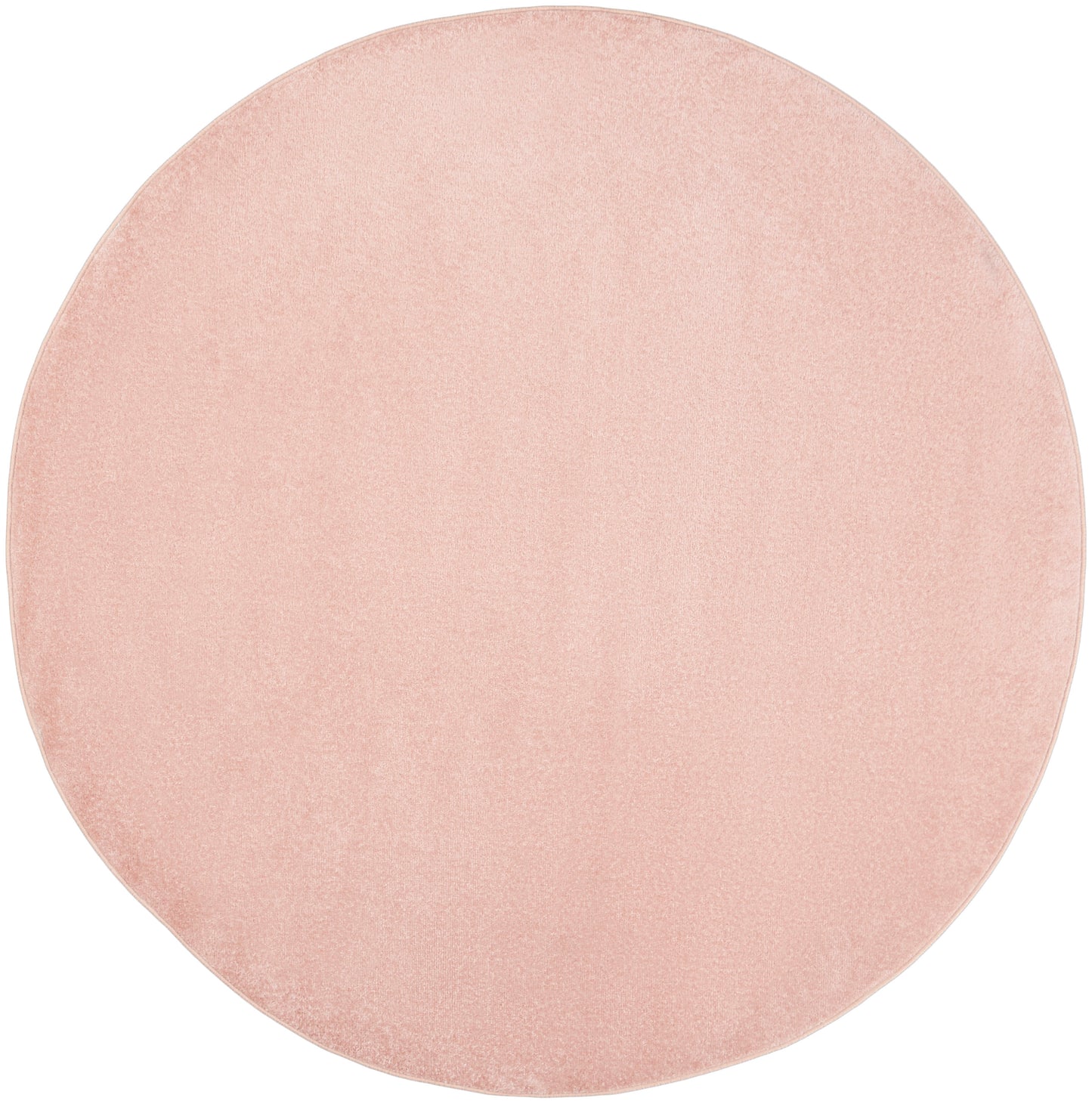Blush pink round outdoor rug with a textured surface.