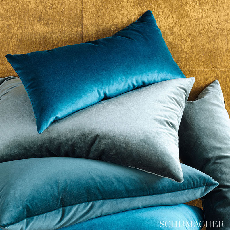 Velvet hazel rectangular throw cushions stacked against a mustard wall.