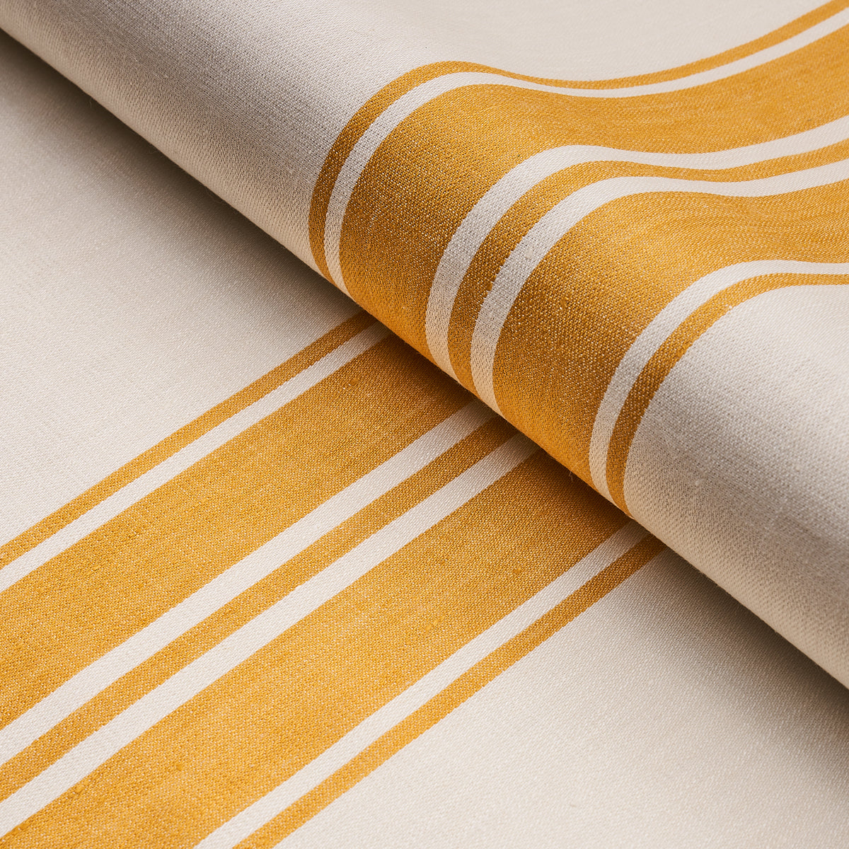 Beige woven fabric with bold yellow and white stripes, rolled textile for home decor or table linens.