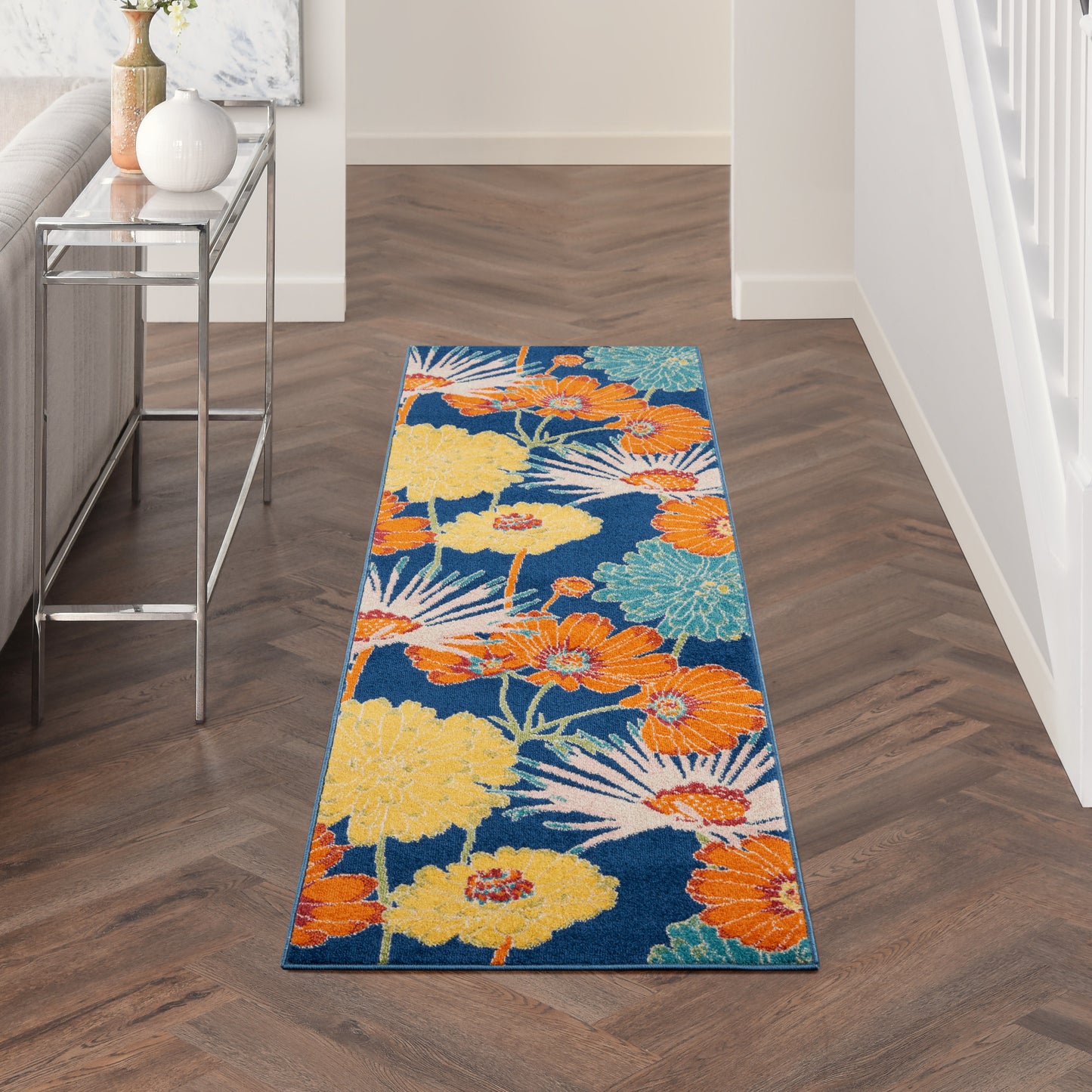 Blue floral hallway runner rug with orange, yellow and teal flowers in a modern foyer.