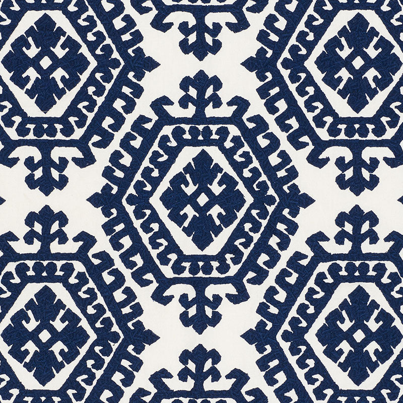 Navy blue geometric diamond tile pattern on cream background; repeating textile print for upholstery or wallpaper.