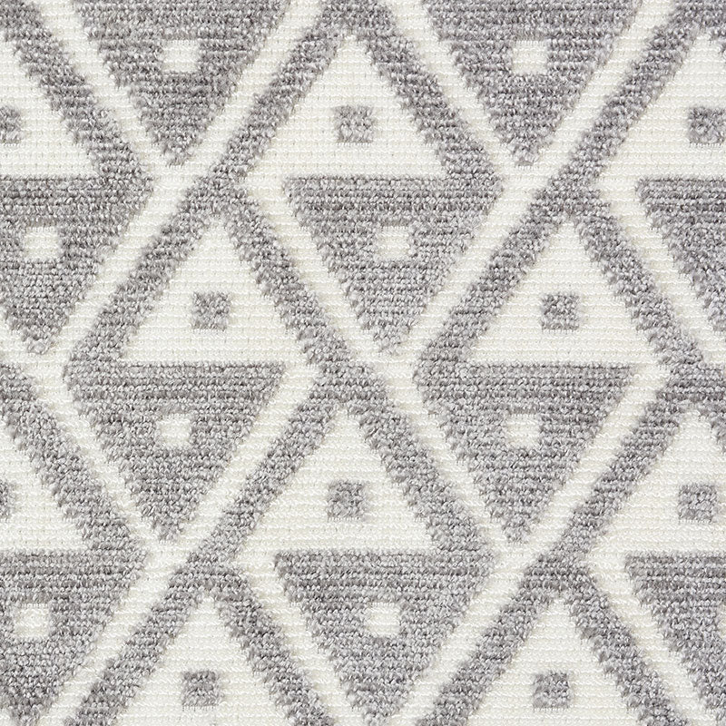 Gray and white geometric diamond textile rug with interlocking triangles and tiny square accents.