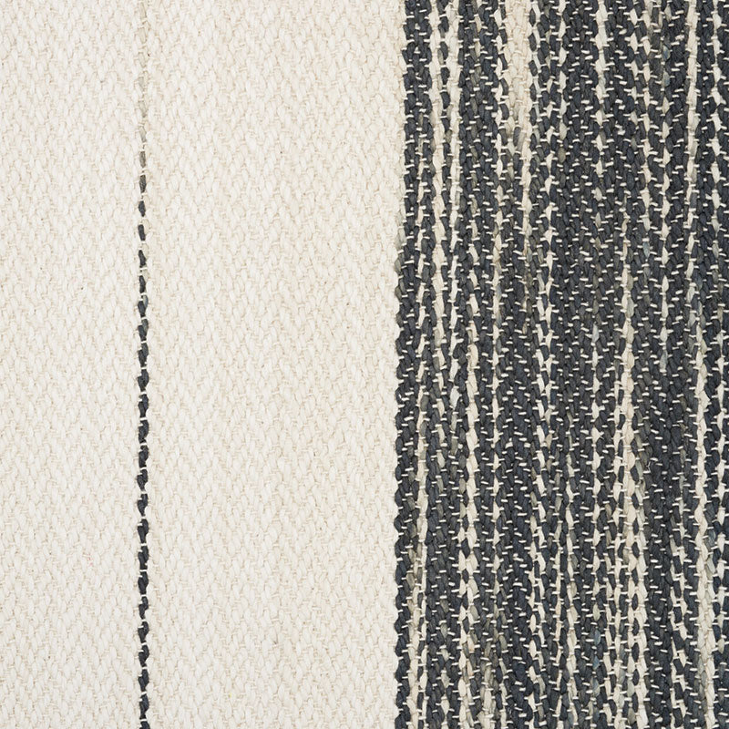 Cream and navy woven rug with vertical panel contrast; left cream section, right navy striped section.