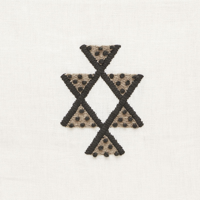 Beige linen with black-stitched triangles forming a star-like cross; beige triangles dotted with tiny black beads.