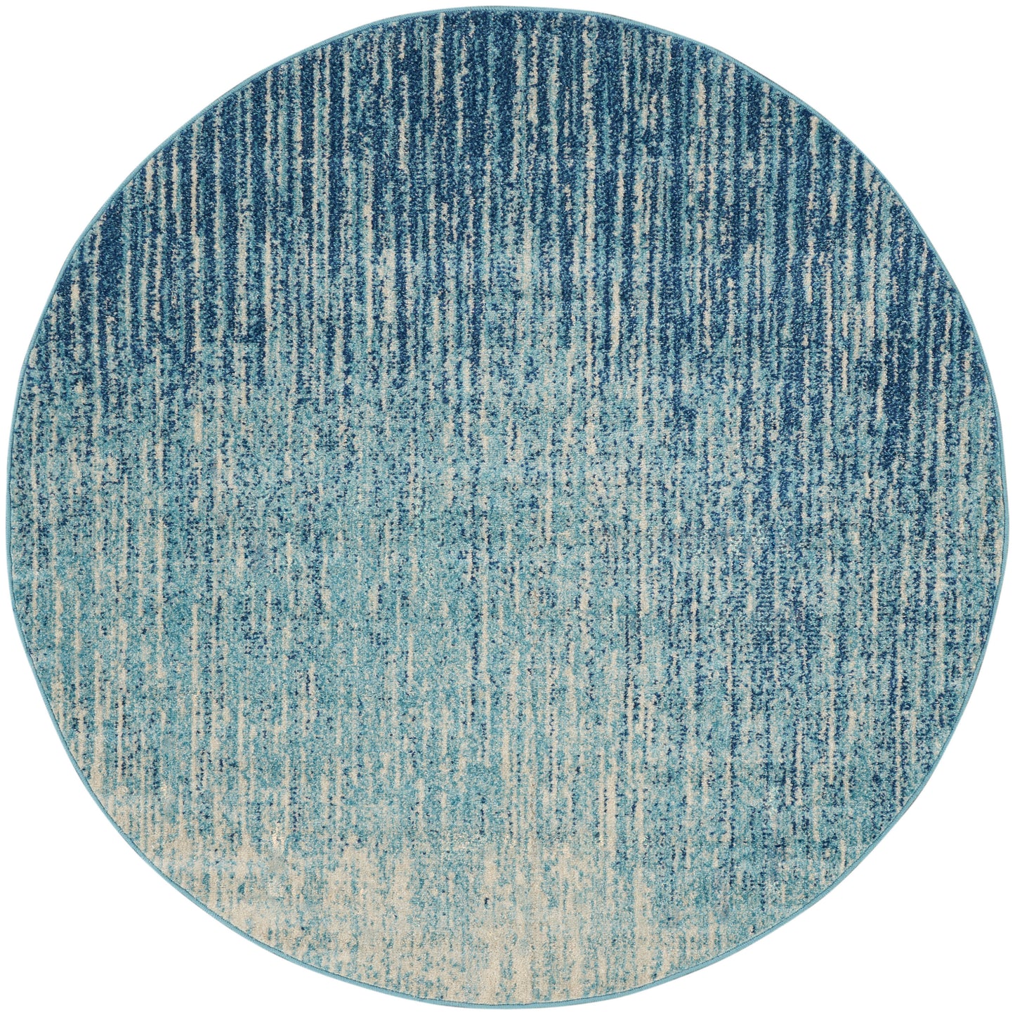Round blue gradient rug with vertical streaks from navy to teal, fading to beige.