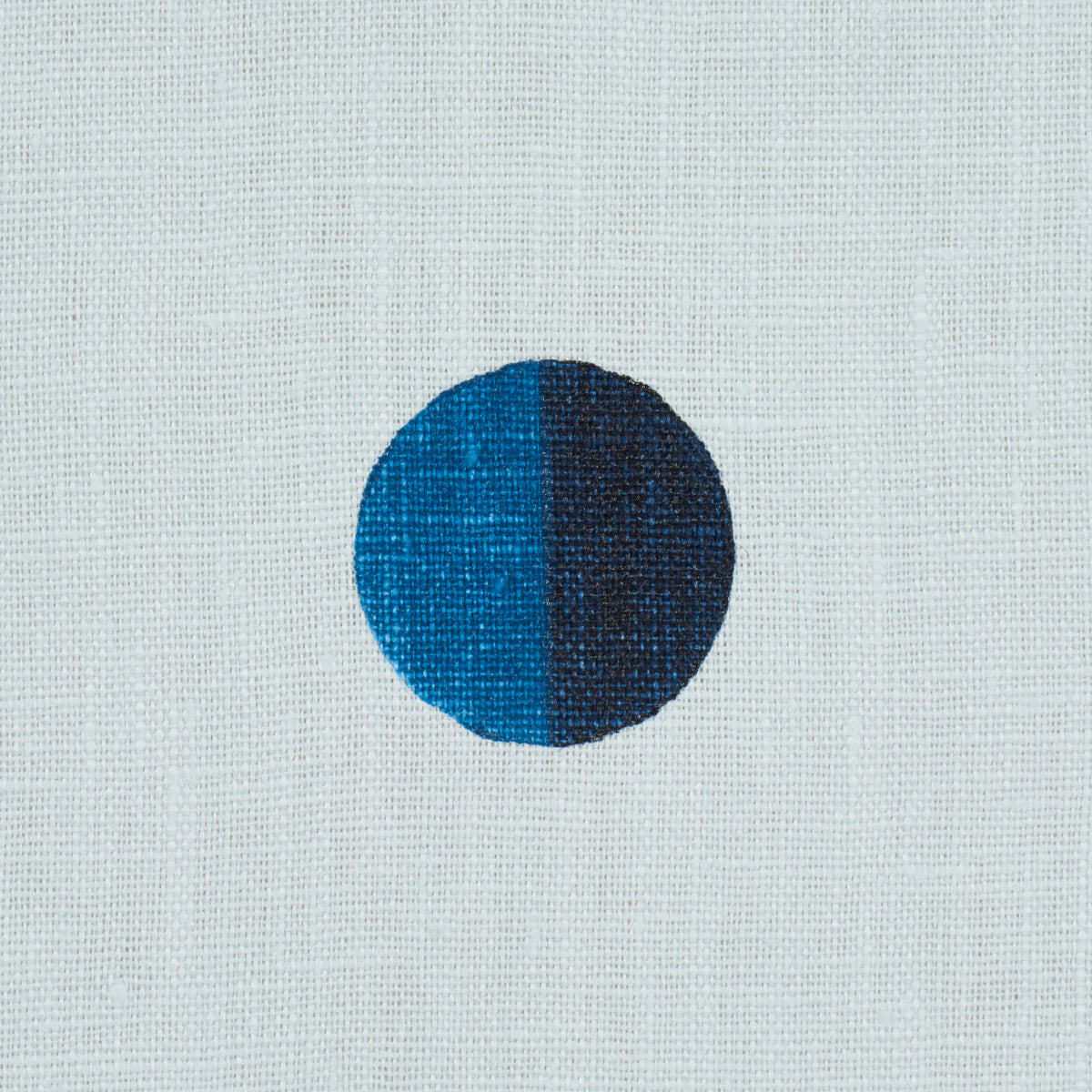 Circular two-tone dot: left bright blue, right dark navy on sky blue background; minimalist geometric textile print.