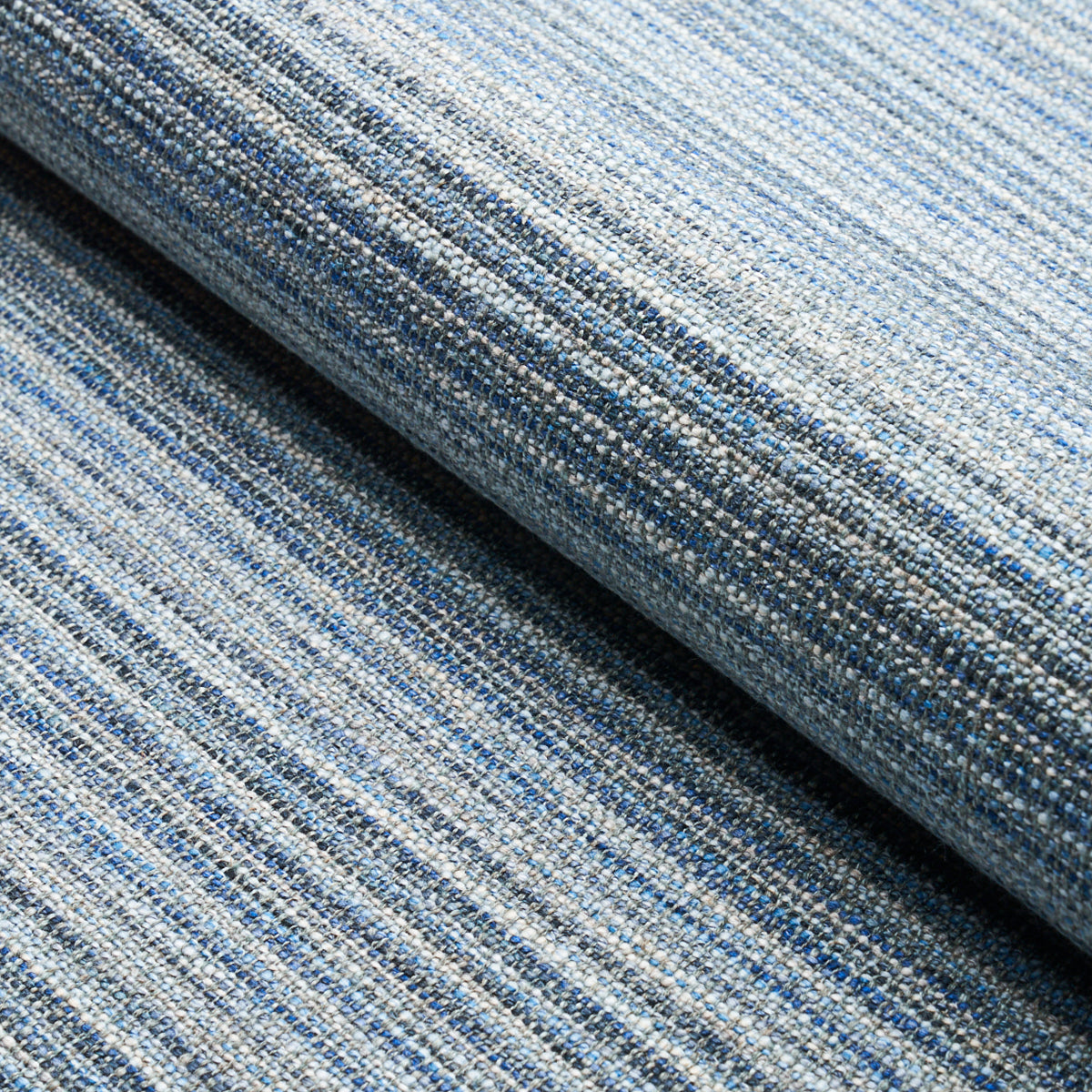 Blue striped woven fabric roll with light and dark blue threads; denim-like textured upholstery material.