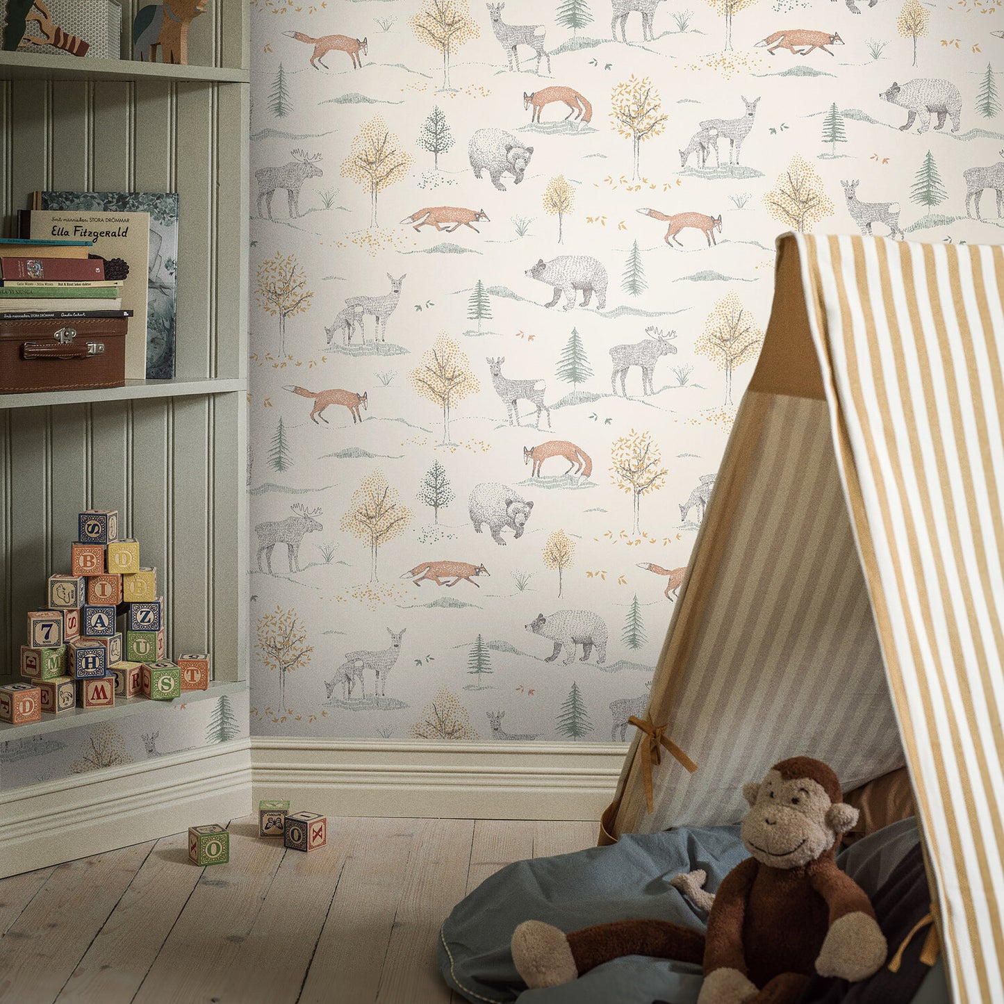 Kids' playroom with woodland wallpaper, striped teepee, blue blanket, stuffed monkey, wooden floor, alphabet blocks.