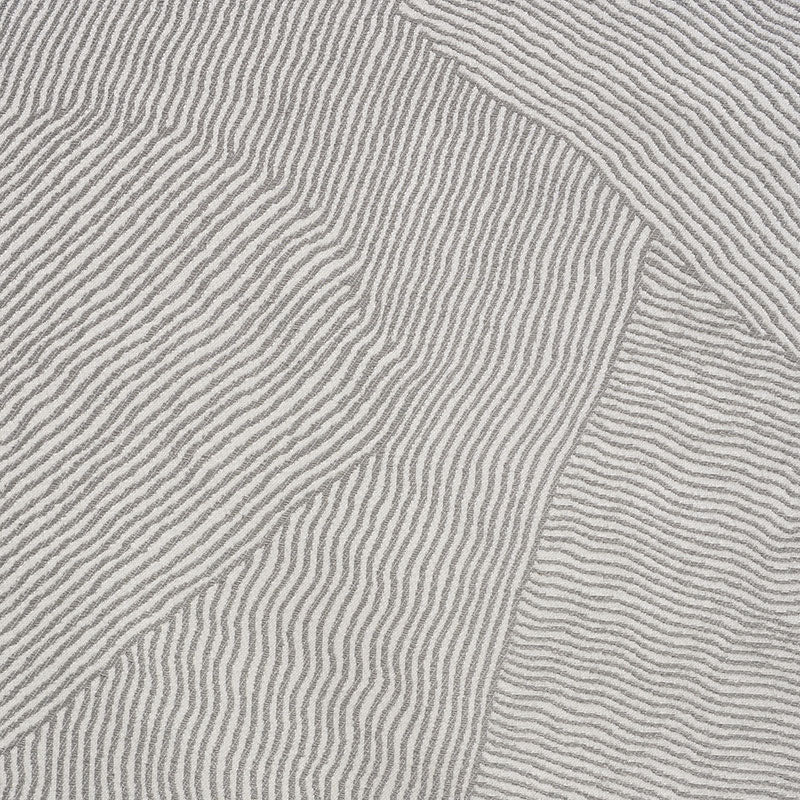Close-up of light gray-beige patterned woven fabric with raised parallel ribs and a patchwork seam.