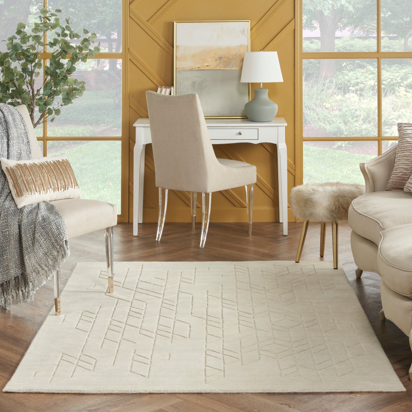 Cream area rug with subtle geometric lines in a yellow-walled living room; white desk, beige upholstered chair, and lamp.