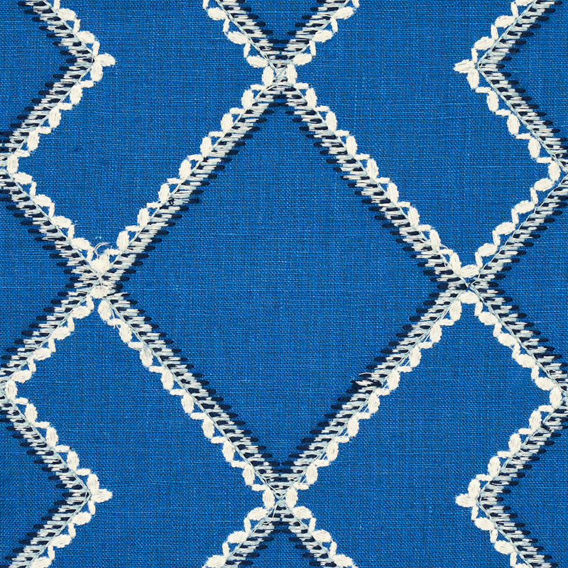 Blue embroidery fabric with a white zigzag-stitch diamond lattice pattern.