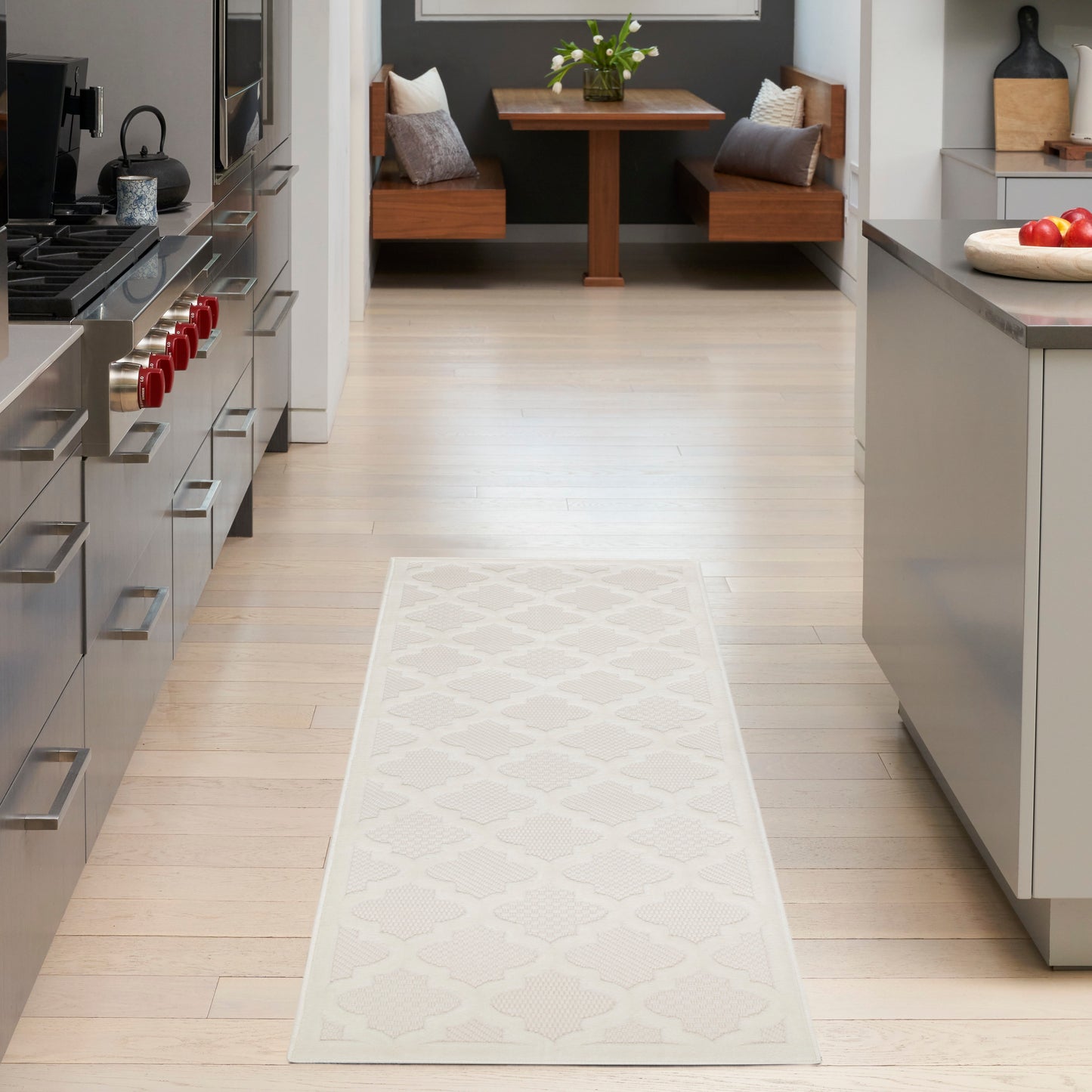Cream patterned outdoor runner rug on a light wood deck with a seating area.