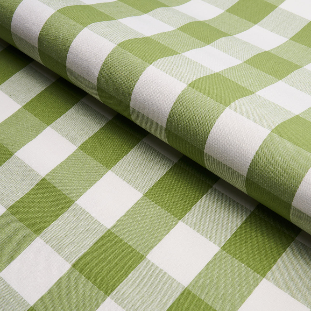 Green and white gingham cotton fabric rolled, checkered pattern, ideal for tablecloths, sewing and crafts.