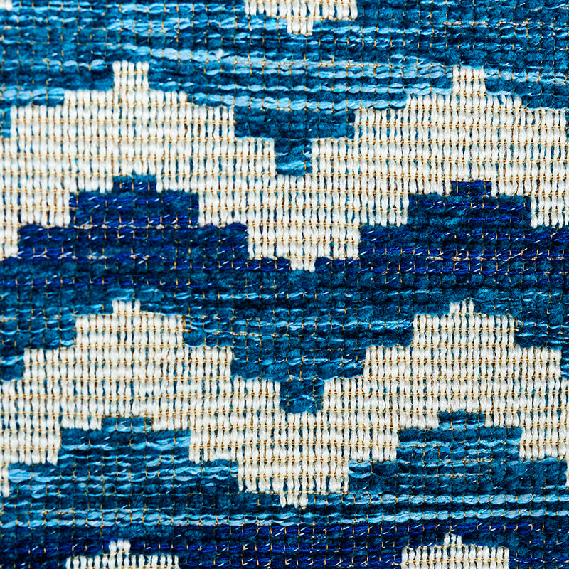 Blue and white woven rug with a zigzag diamond geometric pattern.