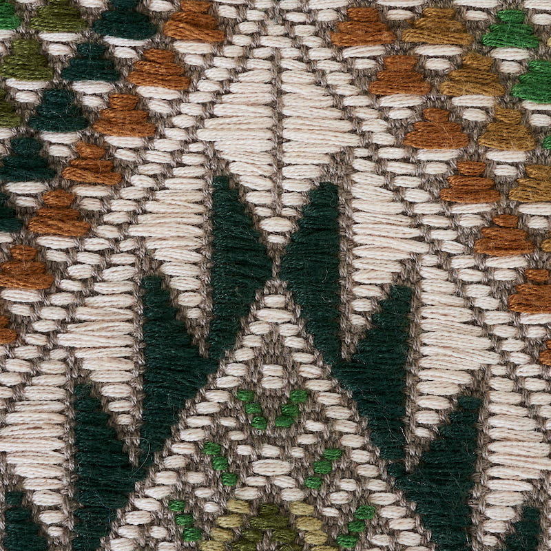 Hand-woven brocade textile with a geometric chevron pattern on a cream background in green, brown, rust, and olive.