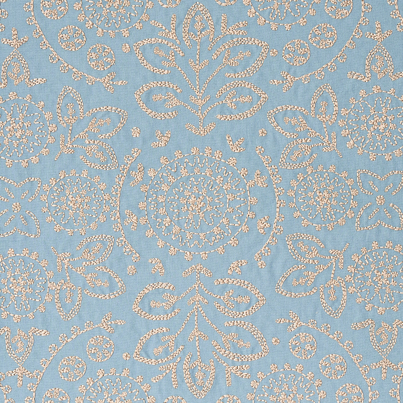 Blue fabric with ivory damask embroidery featuring floral medallions and ornamental scrolls.