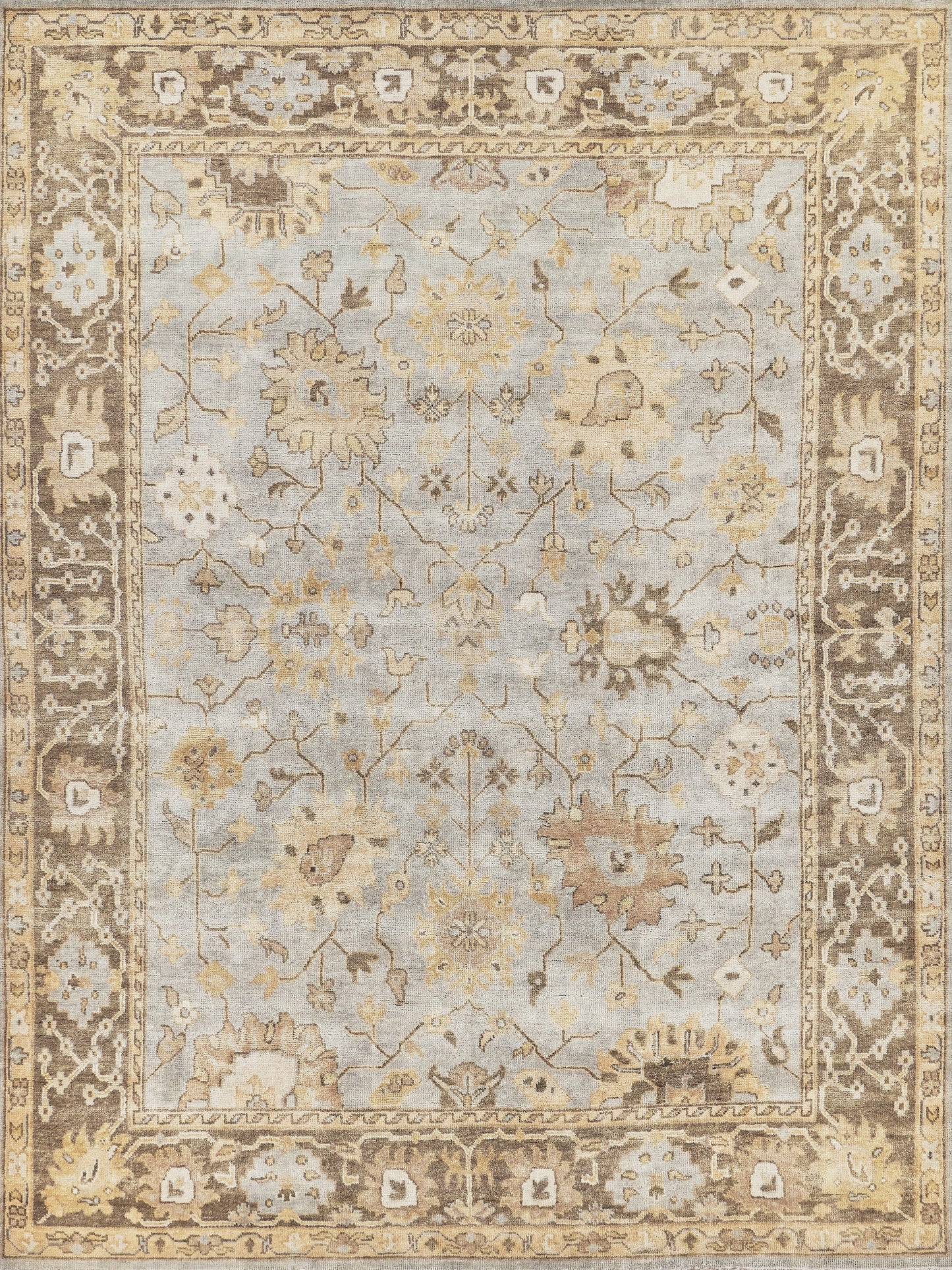 Traditional Oushak-style rug: pale blue field with ivory and tan floral vines, framed by a warm beige-brown ornate border.
