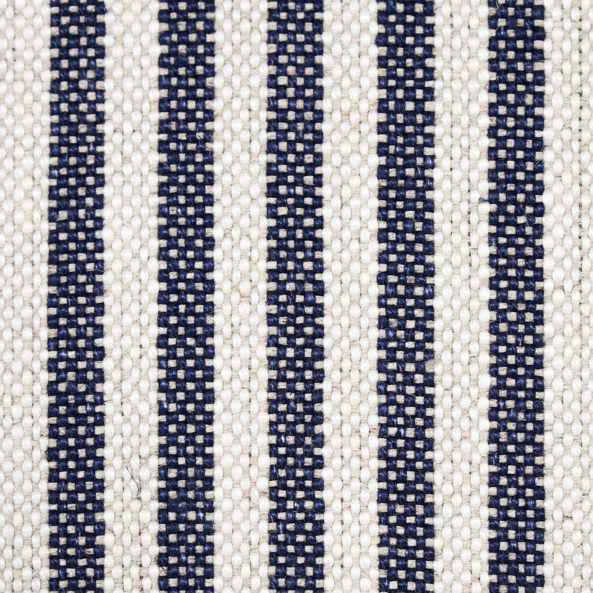 Beige woven fabric with narrow navy blue vertical stripes & textured upholstery weave.