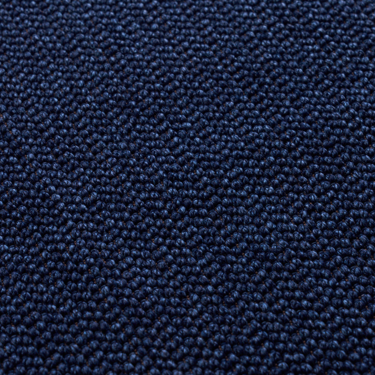 Close-up of dark blue loop-pile carpet with dense, textured fibers.