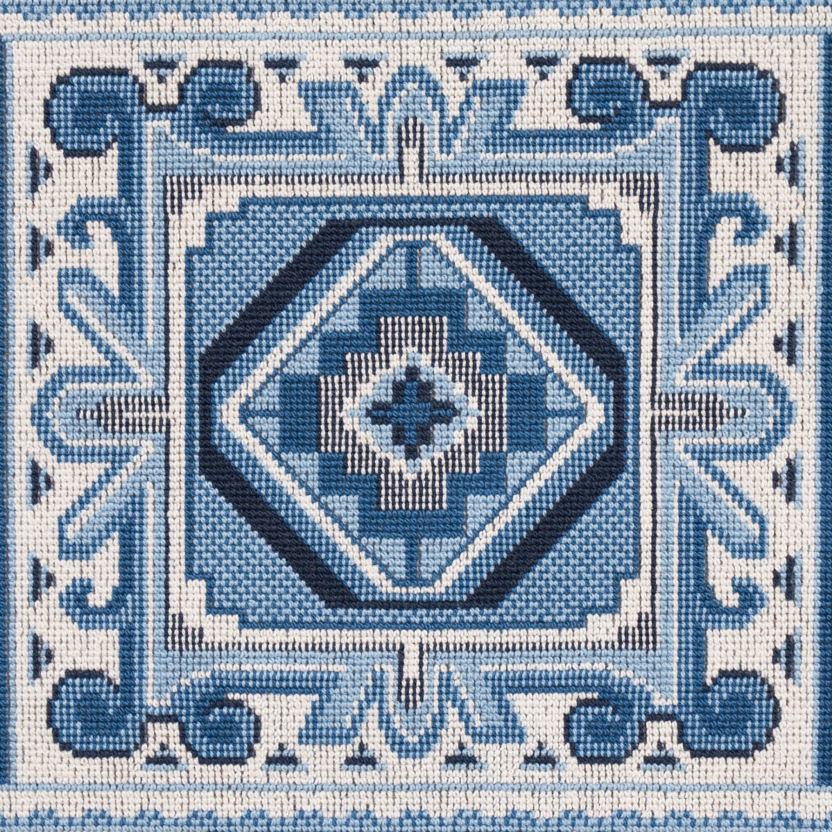 Blue and white woven textile featuring nested diamond patterns, square frames, and an ornate scroll border.