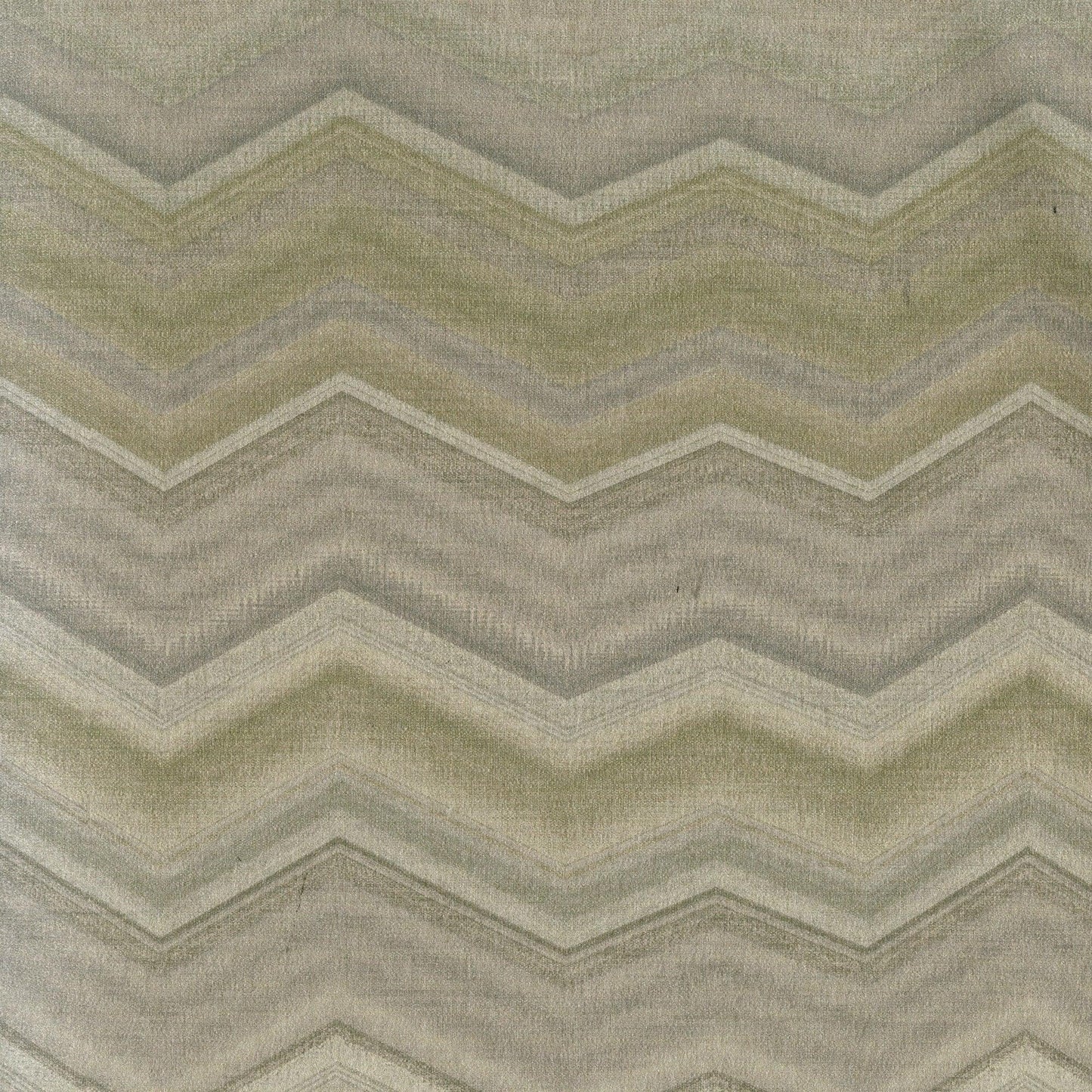 Chevron-pattern rug in muted greens, beige and gray with a soft woven texture.