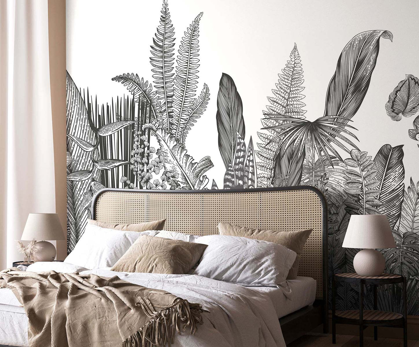 Bedroom with large black-and-white fern mural, beige upholstered bed, white and beige linens, two round bedside lamps.