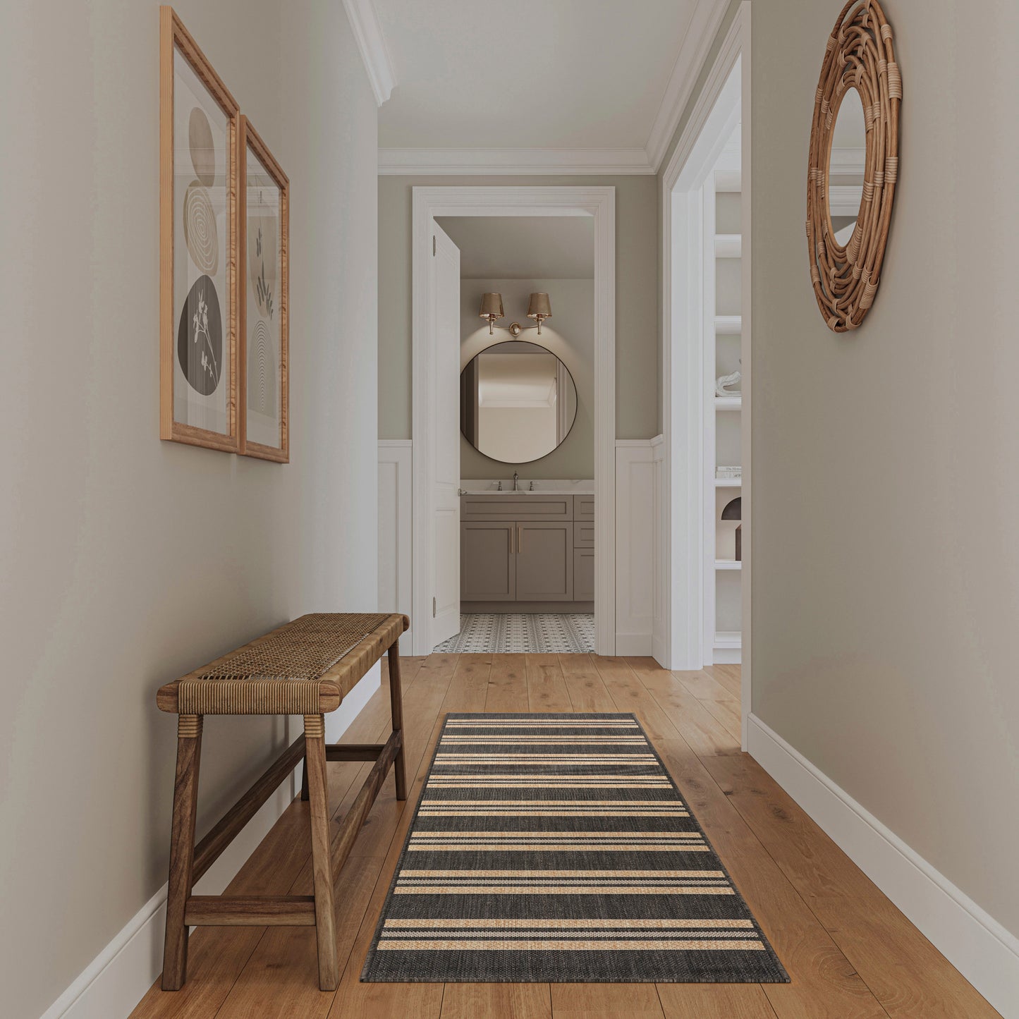 Neutral hallway with wood floor and a modern striped 8' runner rug; woven-seat bench; wicker round mirror, leading to a bathroom vanity.