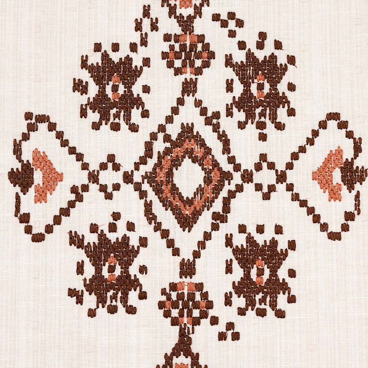 Cream textile featuring brown and peach geometric diamonds in a kilim-style rug pattern.