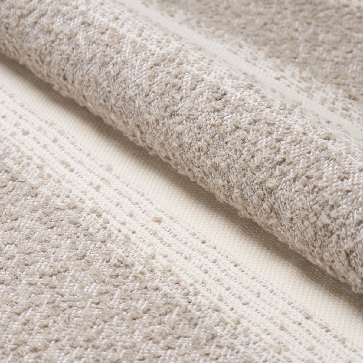 Beige textured rug with soft loop pile and subtle striped pattern, neutral floor covering.