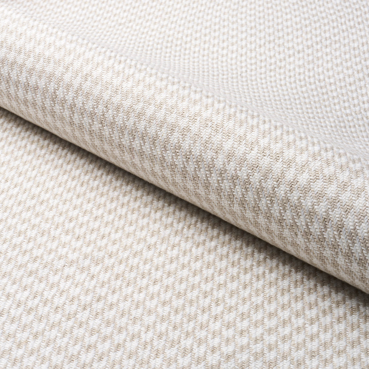Grey woven fabric with a houndstooth pattern and rolled edge; upholstery or drapery textile.