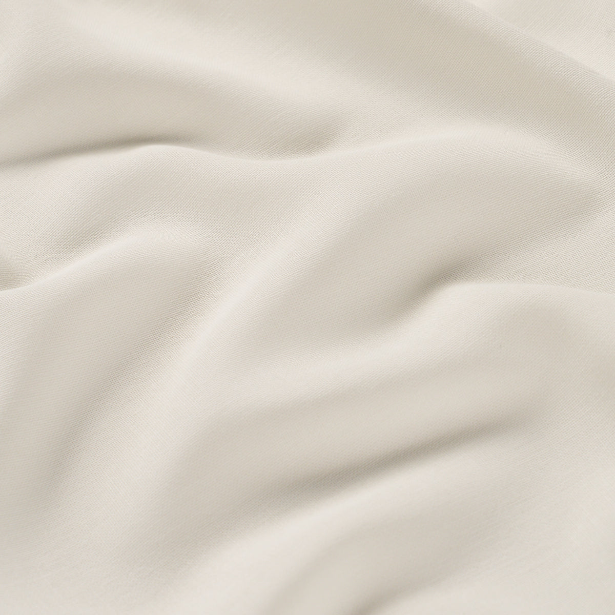 Cream-colored fabric with soft drapes and smooth, fine-textured weave.