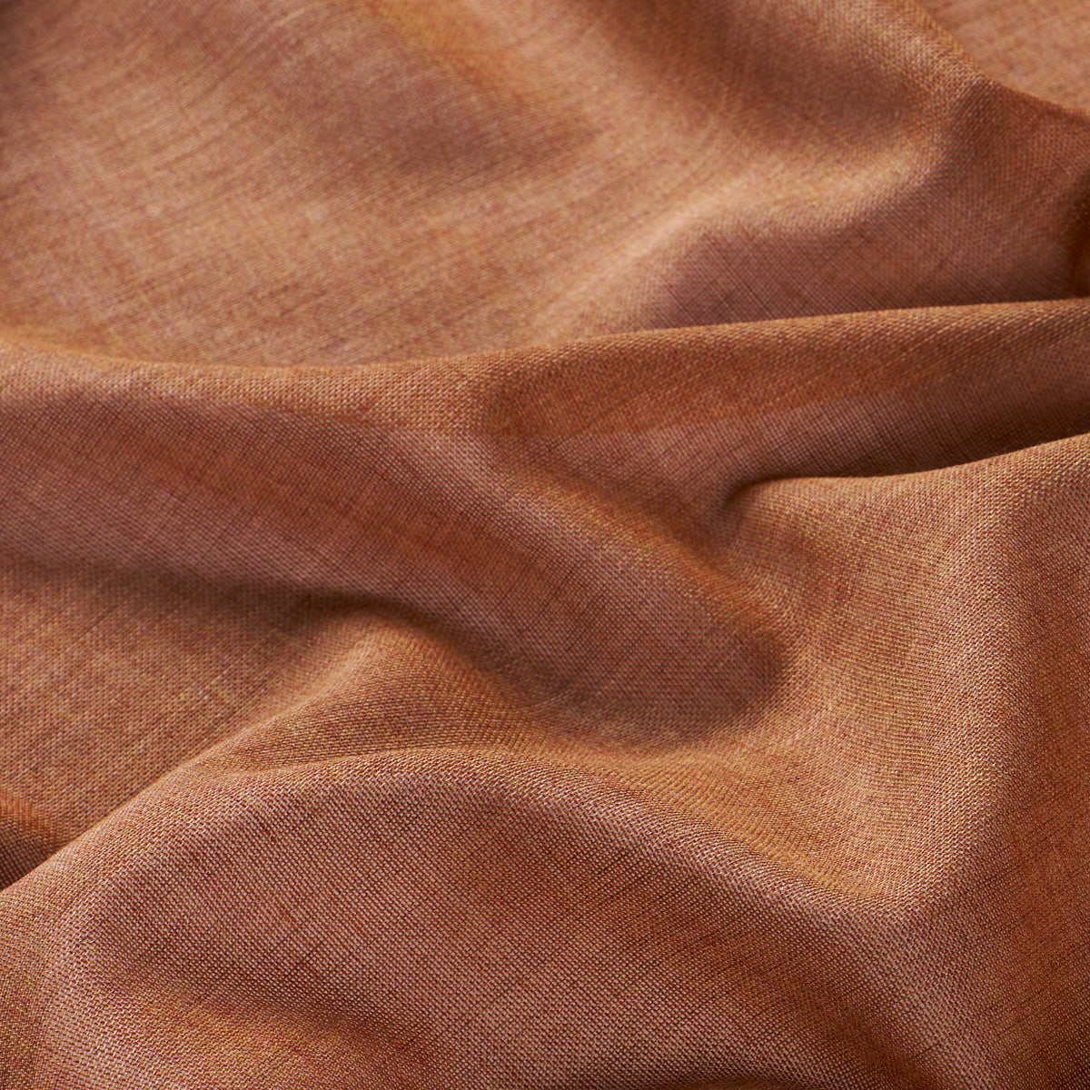 Rust-orange linen-like fabric with visible weave, soft drape and warm earthy tones.