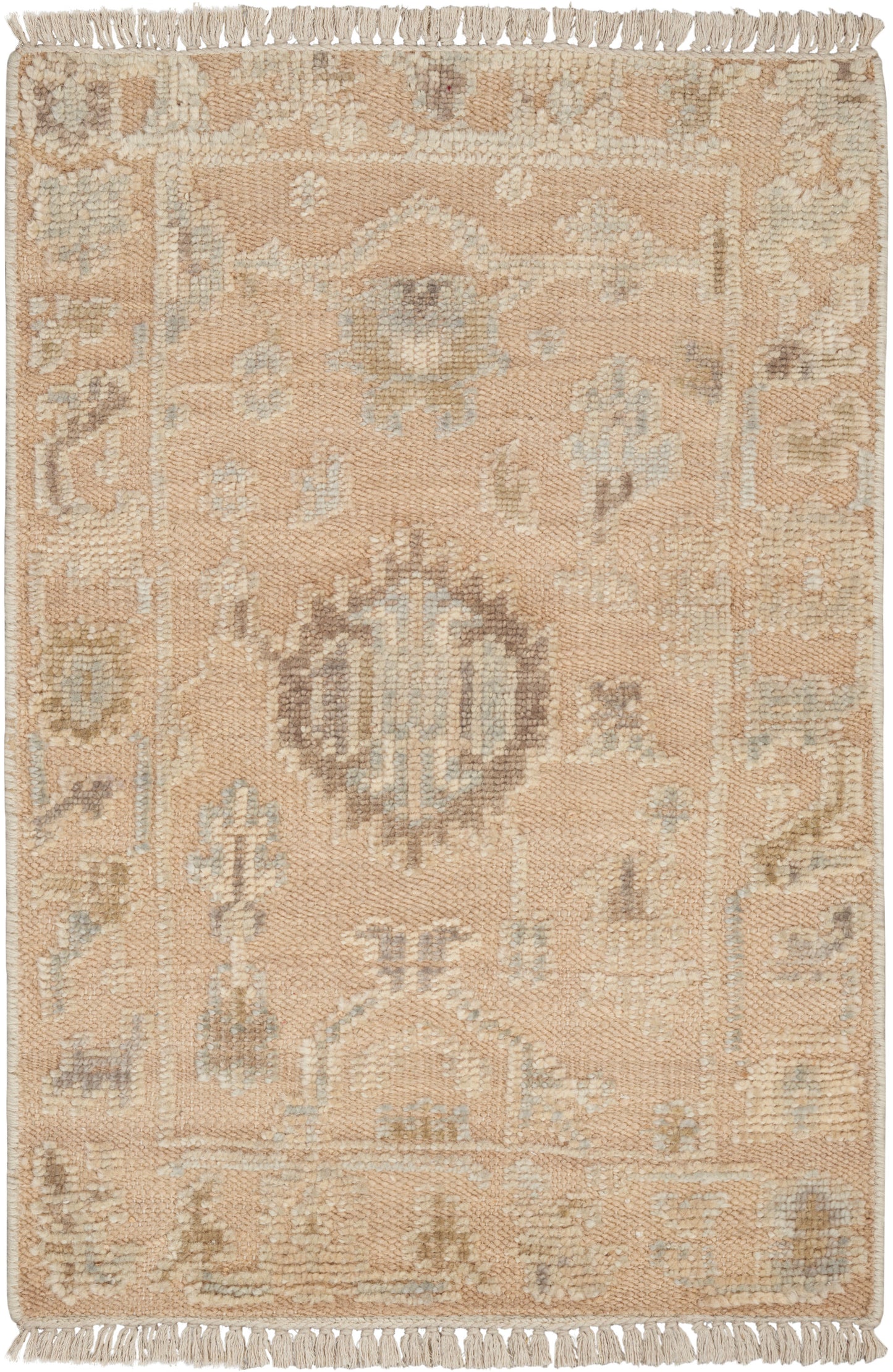 Beige/pale peach rug with light blue/ivory central medallion, geometric motifs & fringe on short ends.