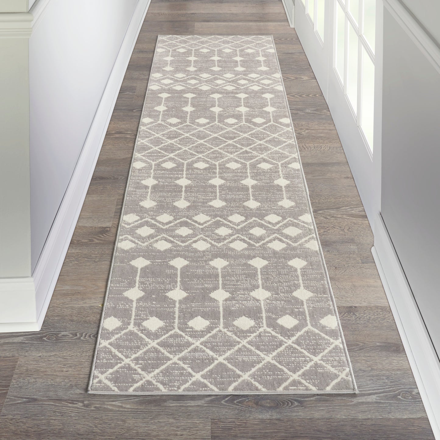 Long gray and ivory geometric hallway runner rug with diamond and lattice pattern.