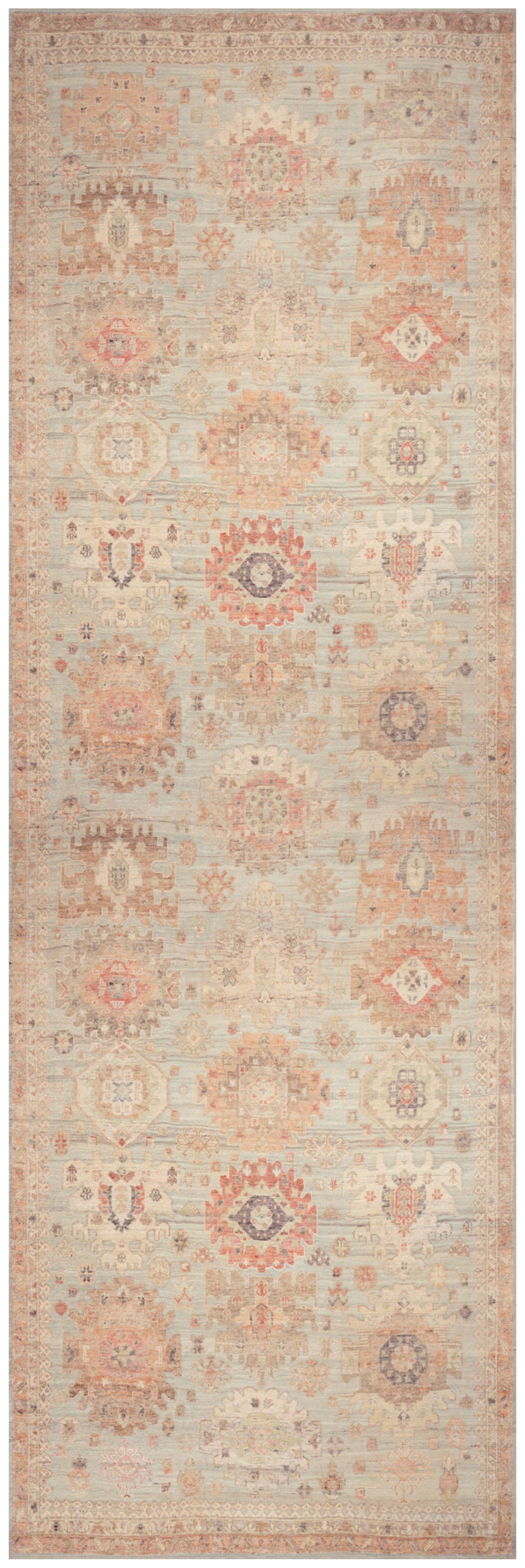 Beige vintage kilim-inspired runner rug with faded peach geometric medallions and pale blue accents.