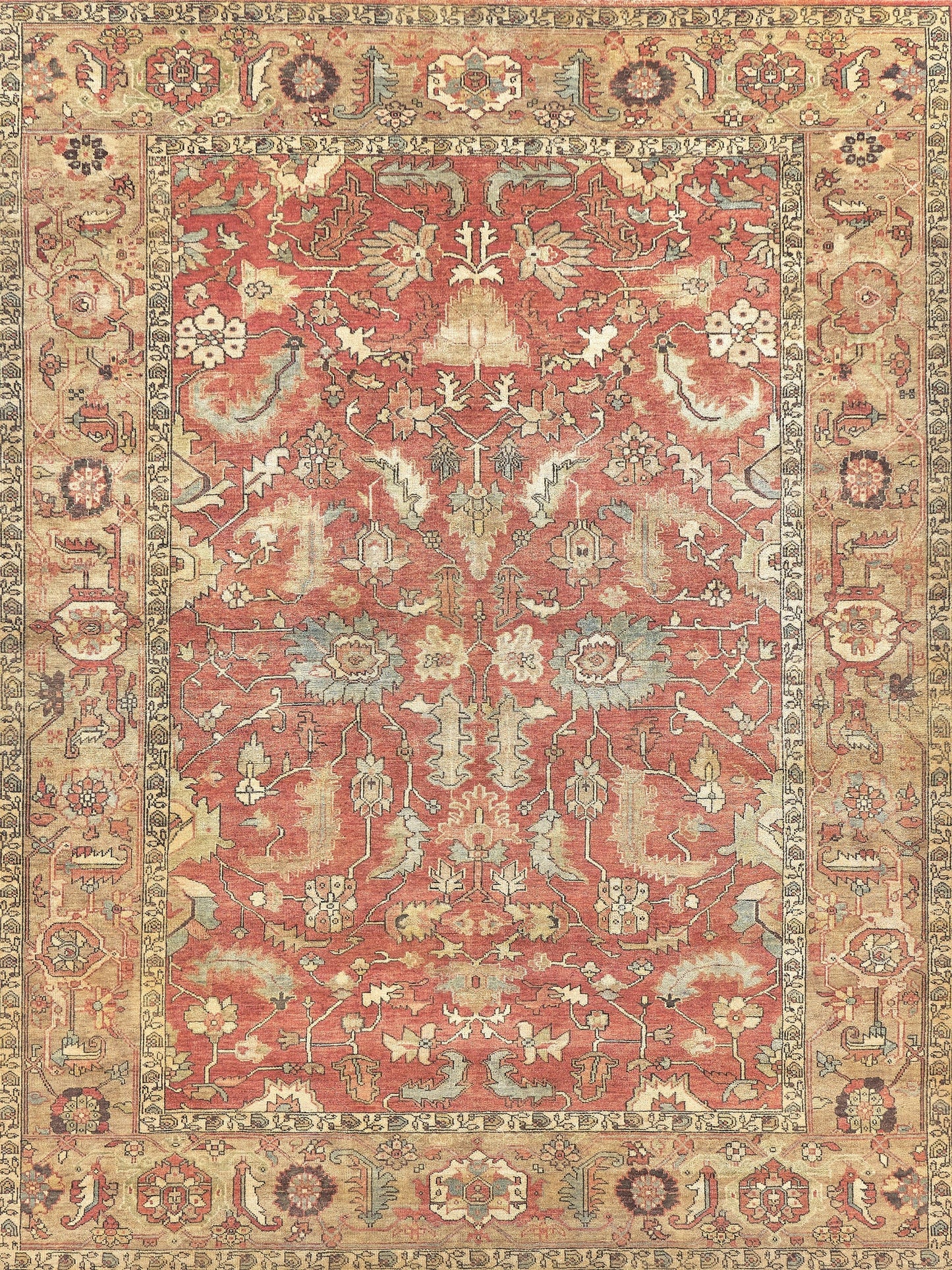 Ornate vintage-style area rug featuring a red background with intricate floral and geometric patterns in blue and cream.
