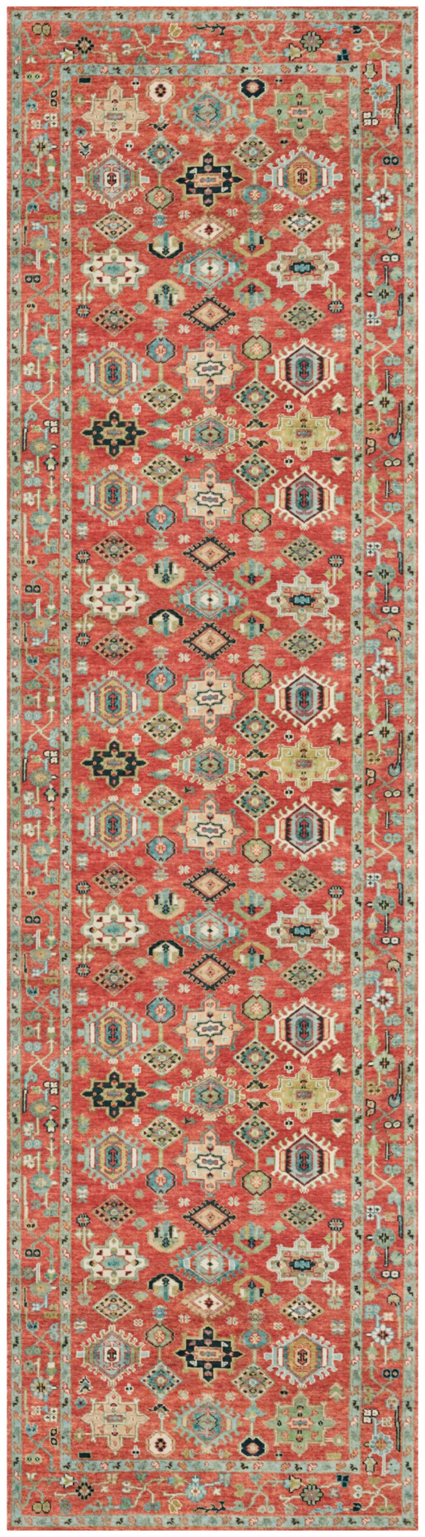 Long oriental-style runner rug with red-orange field, geometric diamond motifs, cream, navy and black accents.
