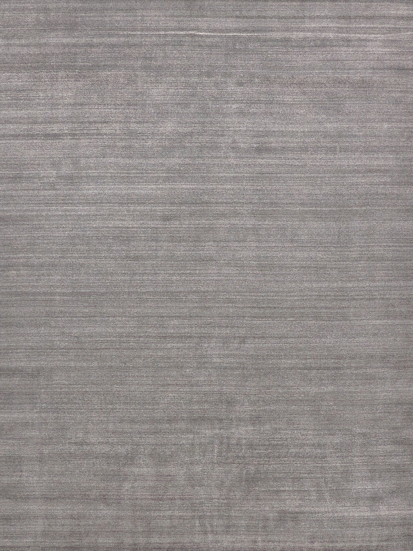 Gray textured rug with subtle brushed pattern and muted tonal stripes, versatile modern home decor.