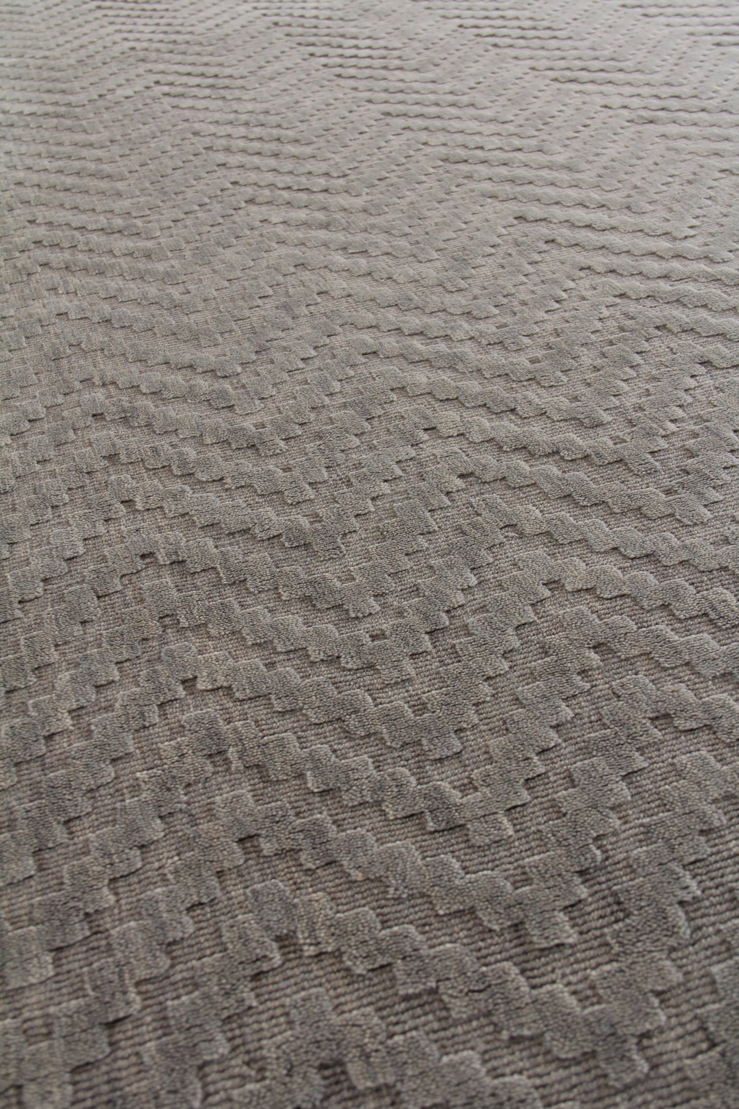 Taupe beige textured rug with a subtle zigzag chevron pattern and soft loop-pile, modern cozy style.