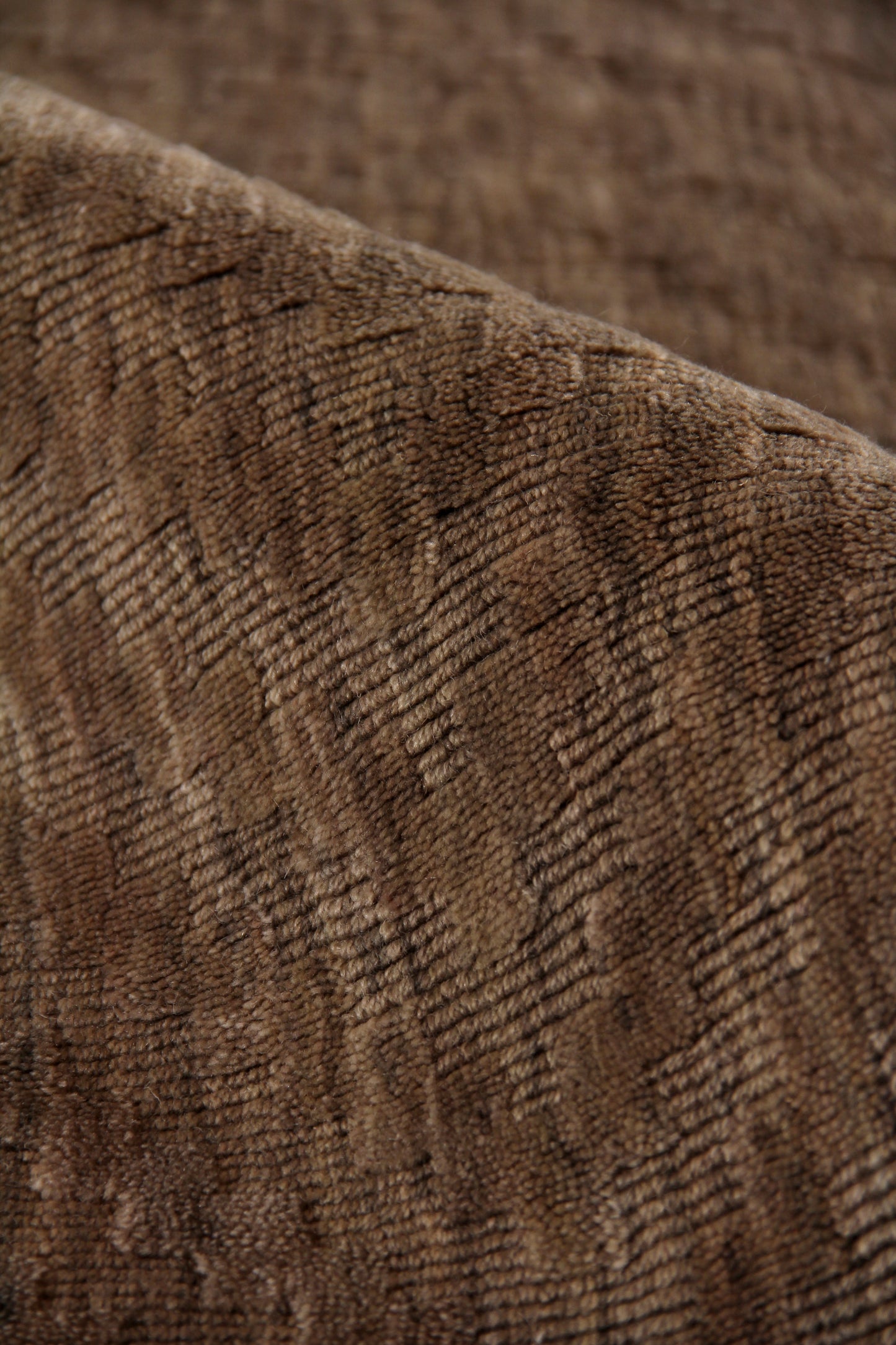 Brown corduroy-like rug close-up with ribbed texture and plush nap.