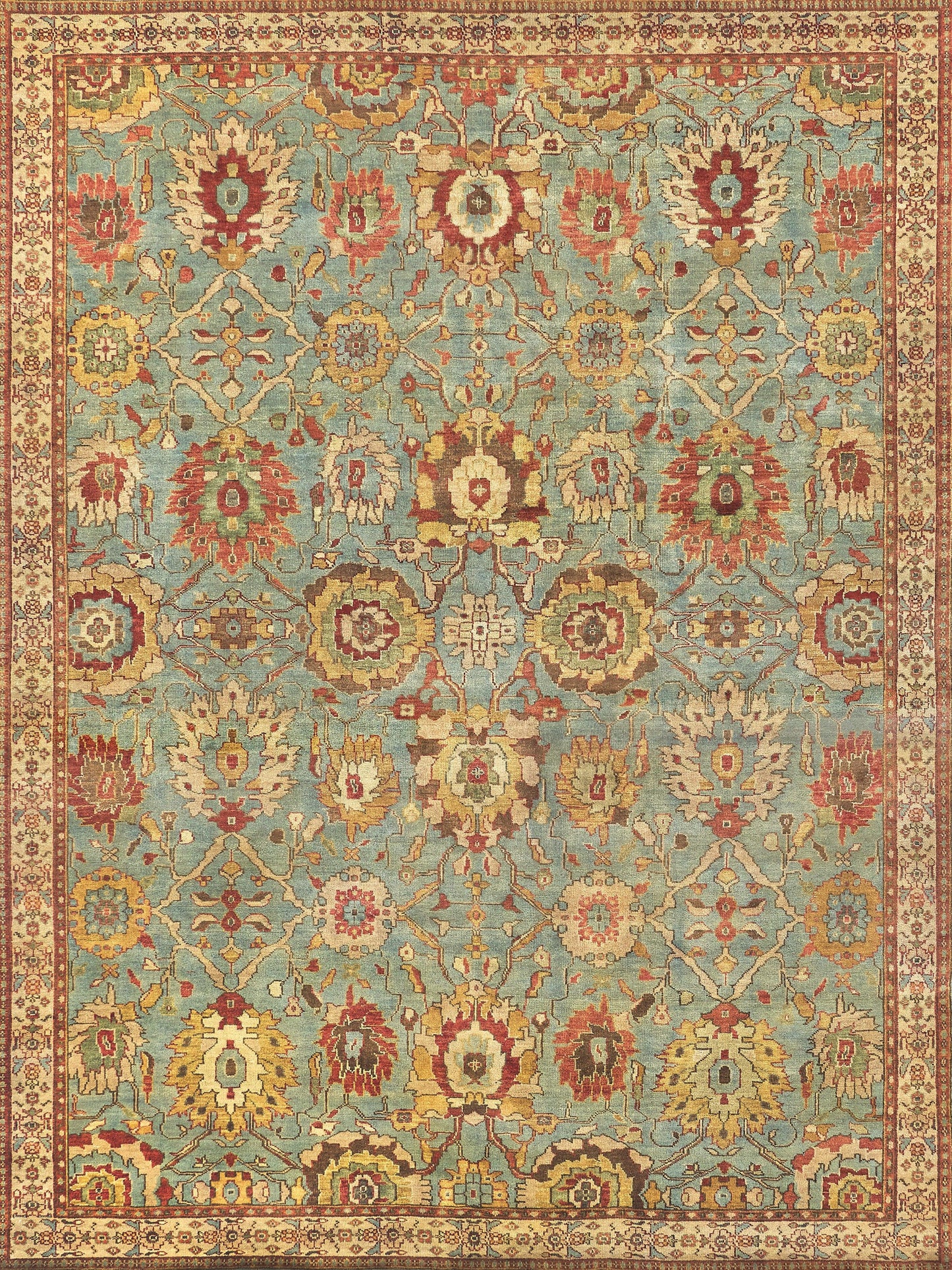 Vibrant vintage area rug with floral motifs in red, yellow, and cream on a light blue background, bordered with intricate designs.