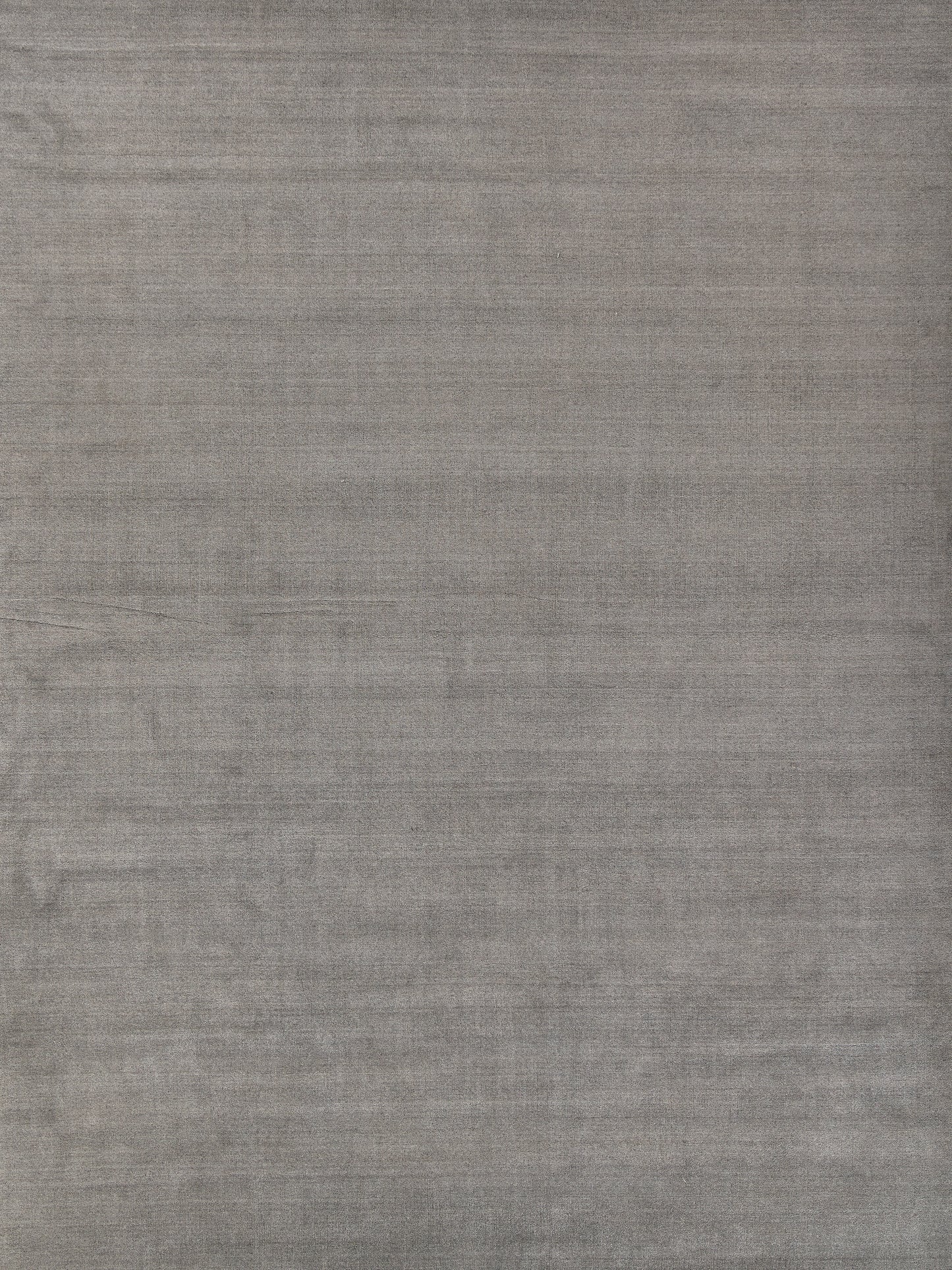 Grey linen-style rug with subtle weave and soft, worn look.
