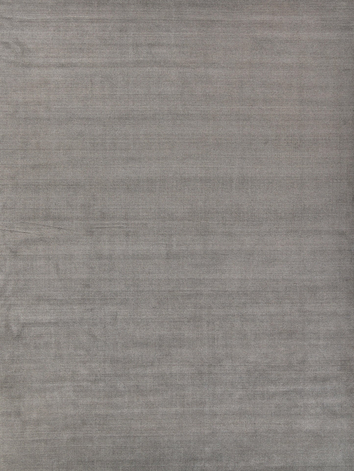 Grey linen-look rug with subtle woven texture and soft folds.