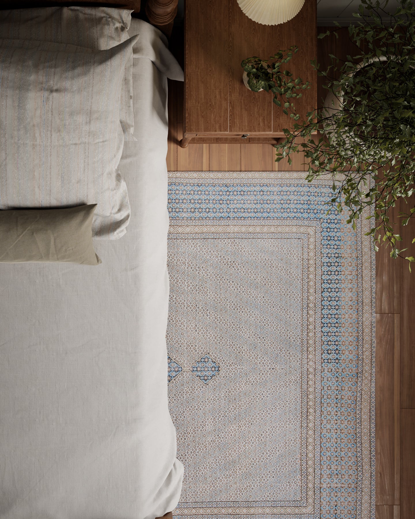 Top-down view of a cozy bedroom: beige bed linens, wooden nightstand, blue-beige patterned runner rug, and a green plant.