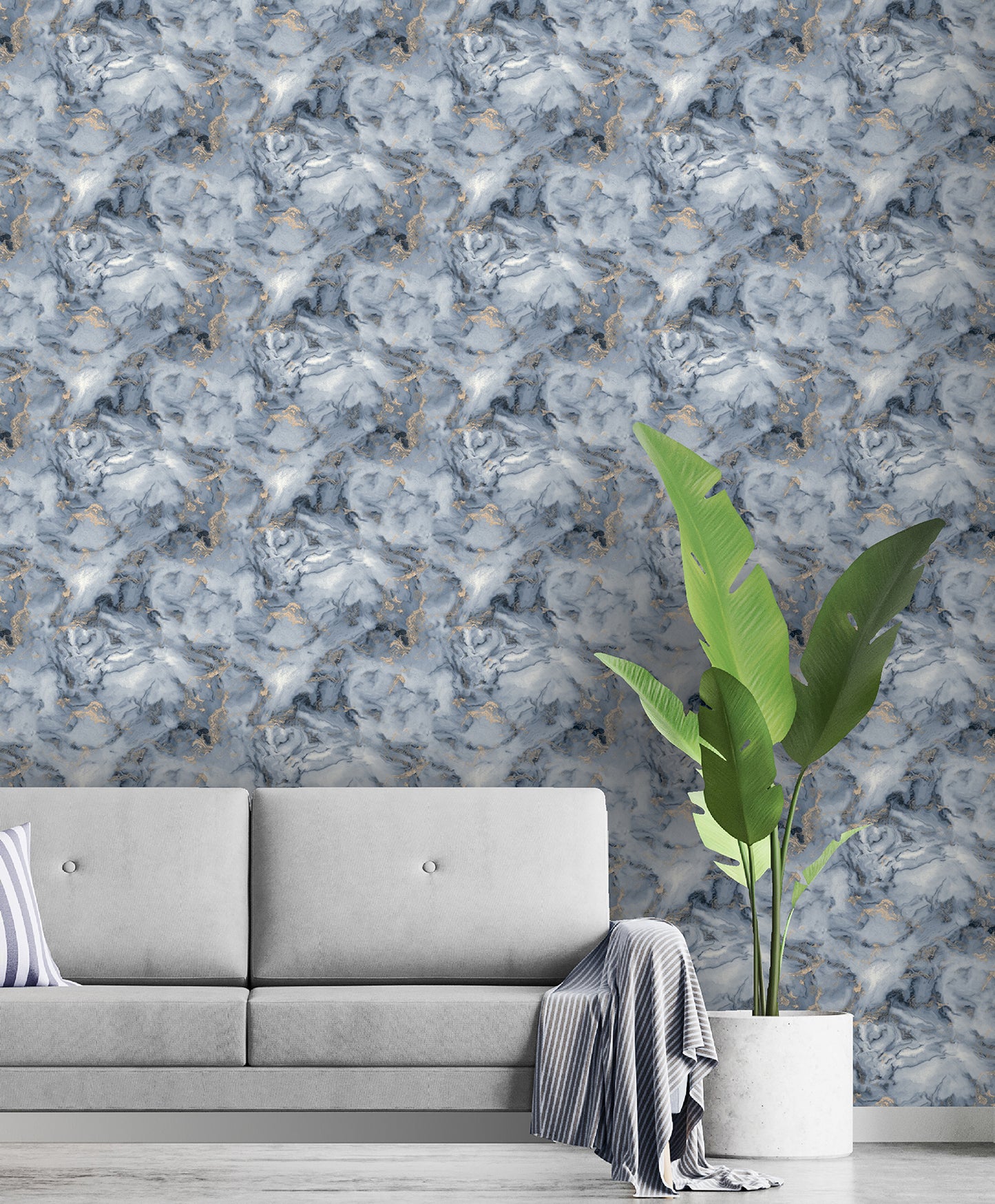 Navy marble wallpaper with gold veining, light gray sofa, striped pillow & throw, tall green plant in white pot.