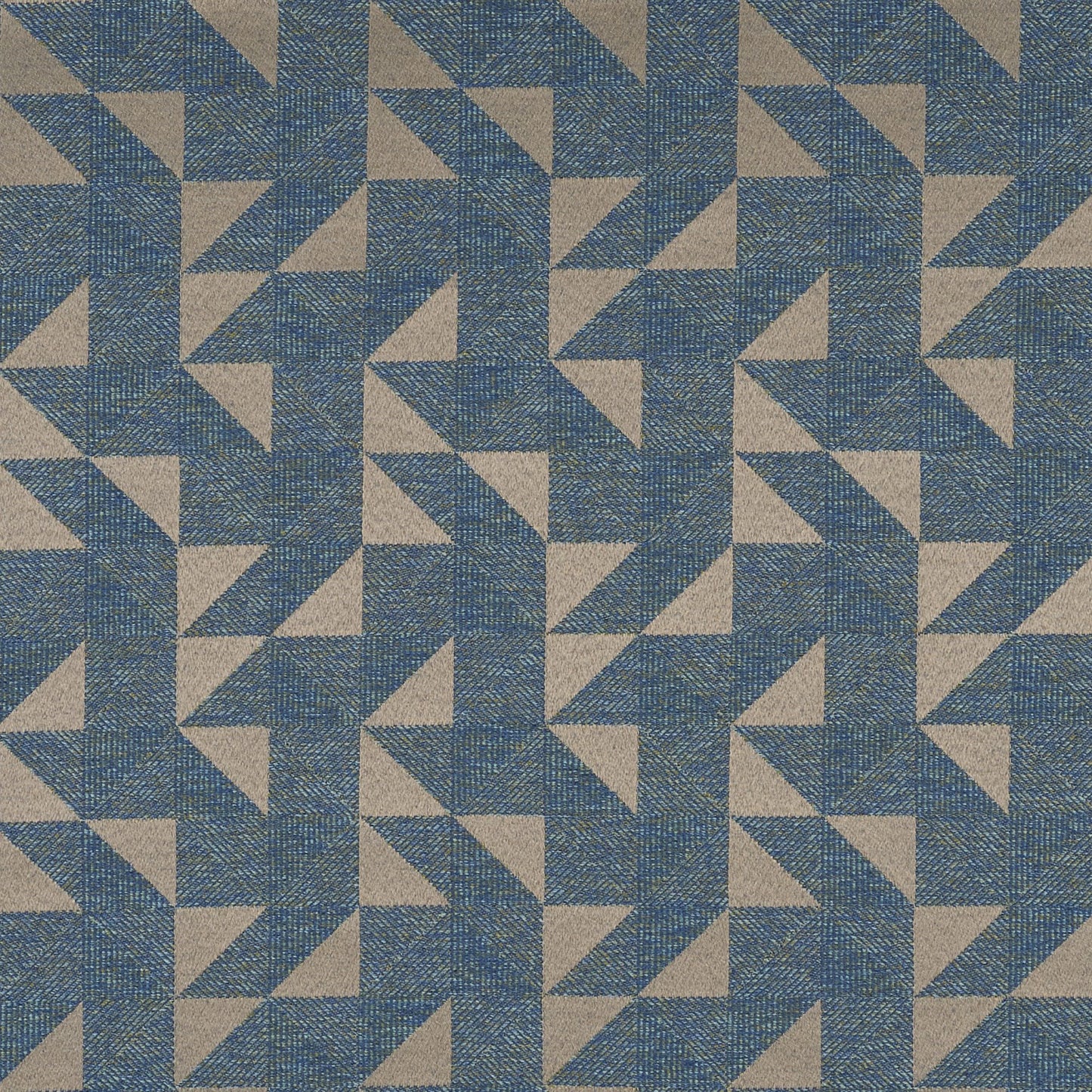Blue, tan and green geometric triangles form a repeating pinwheel pattern on woven fabric.